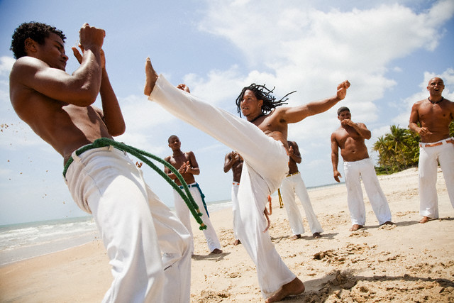 Trancoso, Brazil --- Young Men Practicing Capoeira --- Image by © Blue Images/Corbis